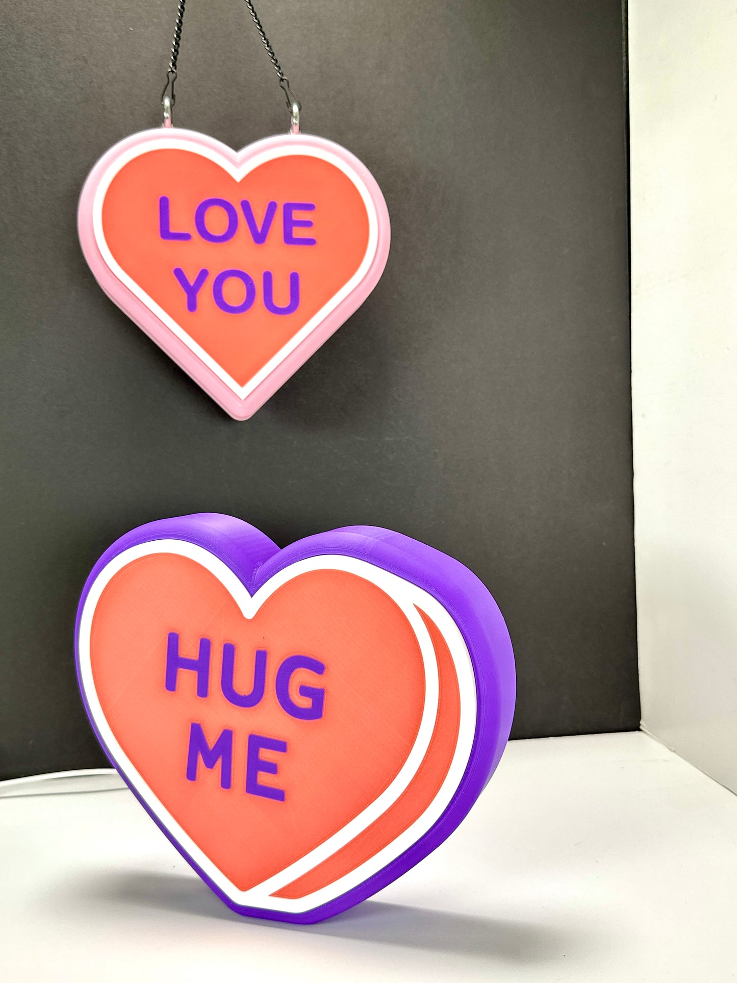 Custom LED heart signs: pink 'LOVE YOU' and purple 'HUG ME.' Valentine’s Day gift
