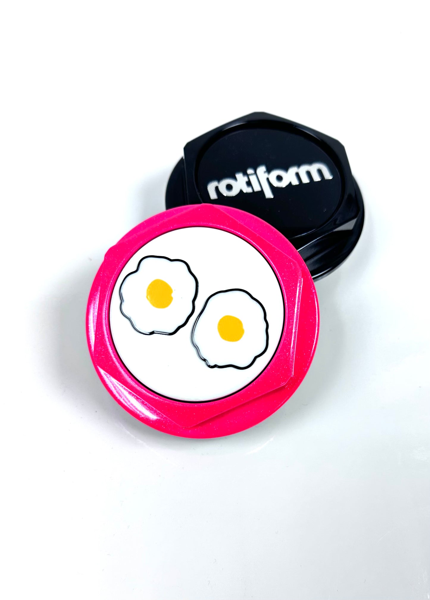 Pink cap with cartoon eggs design and black cap with 'rotiform' branding on a white background