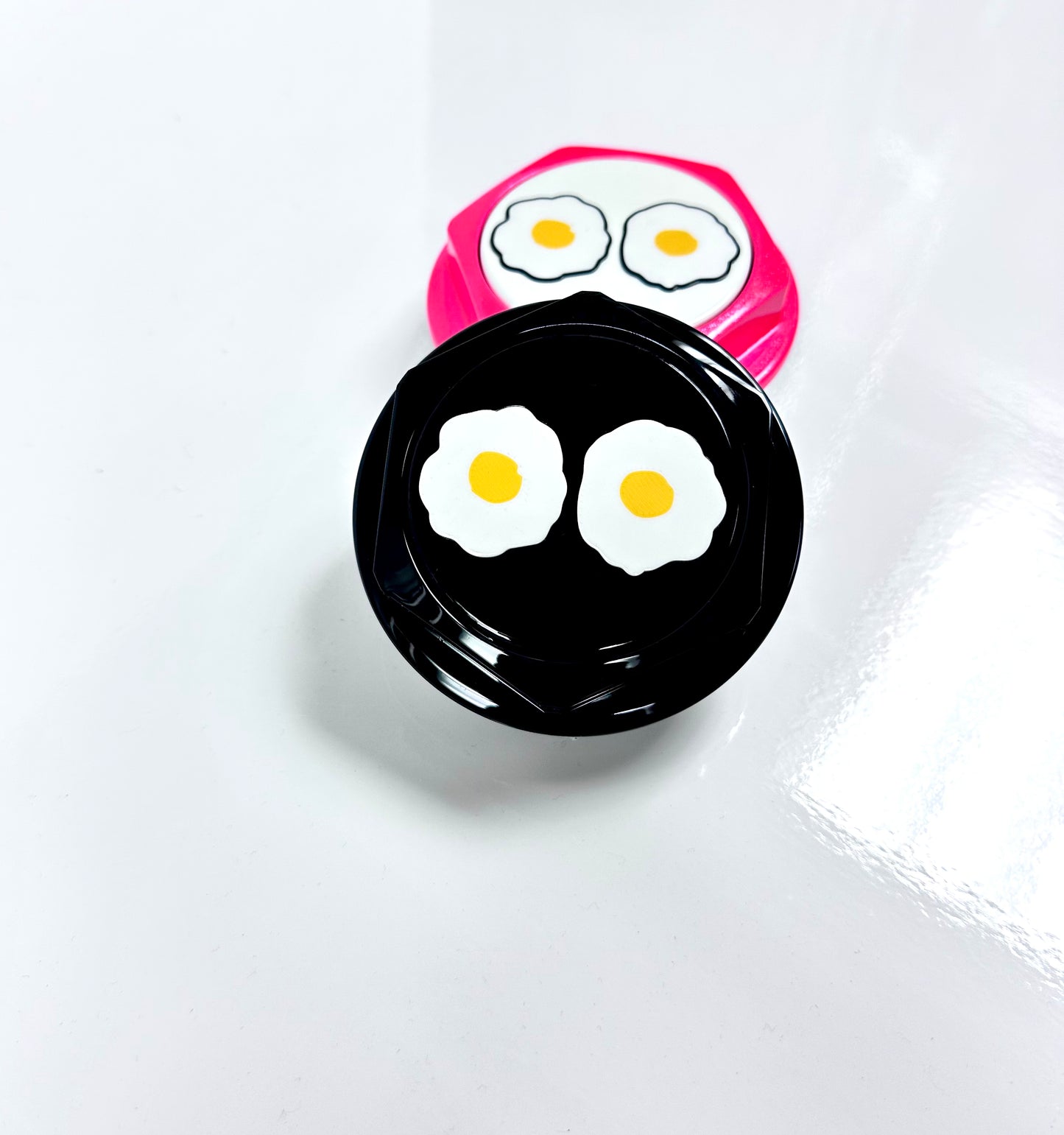 Two novelty hex shaped center cap with egg design on a white background