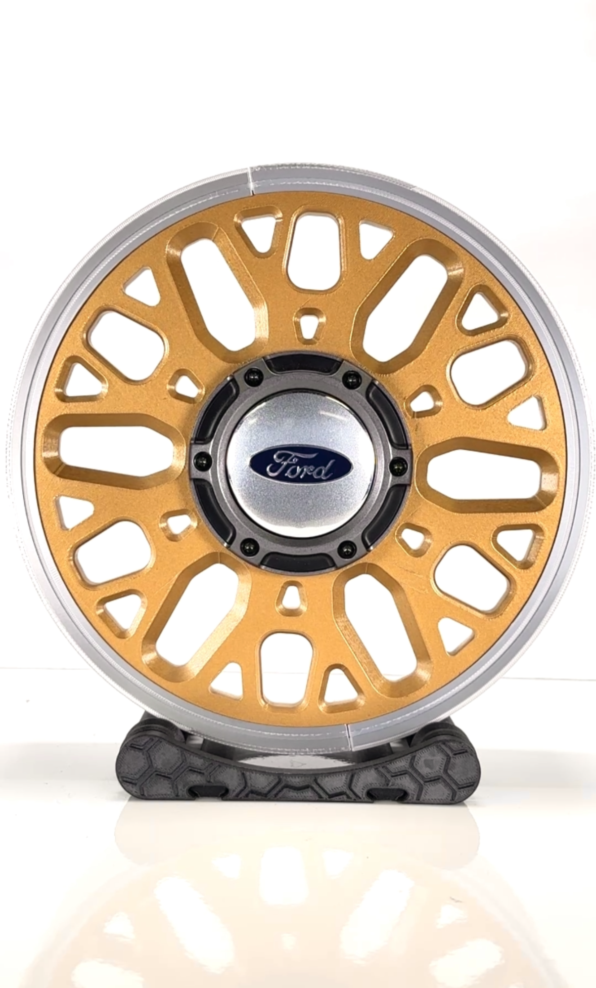 Gold and silver wheel with Ford logo on a white background
