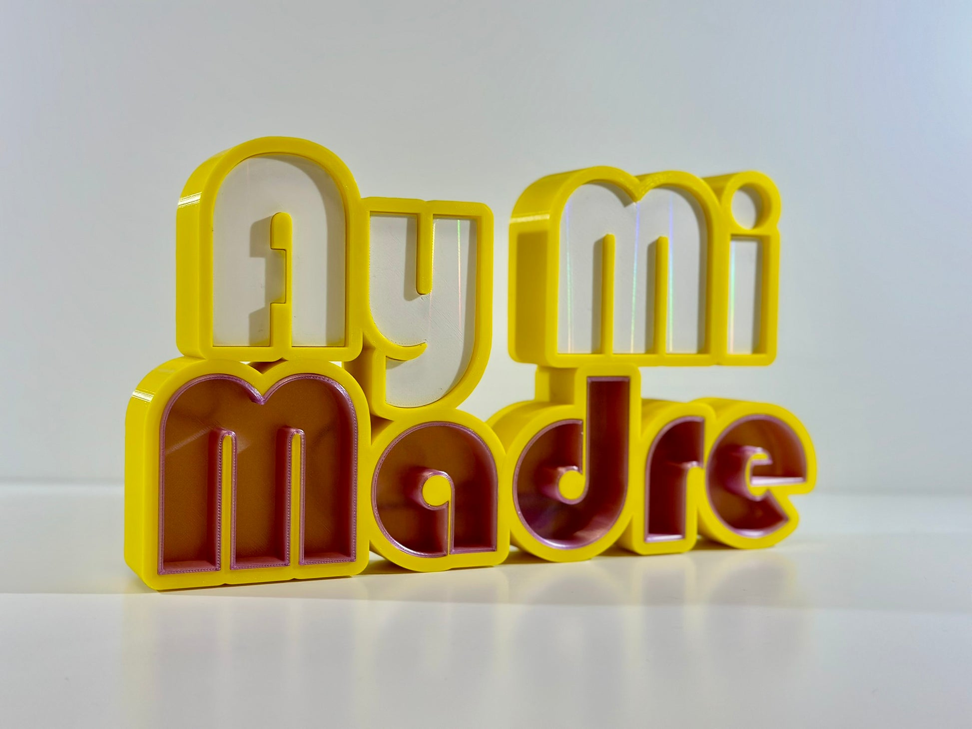 Ay Mi Madre LED Channel Letter Sign in yellow with red and white letters, displayed at an angle against a white background.