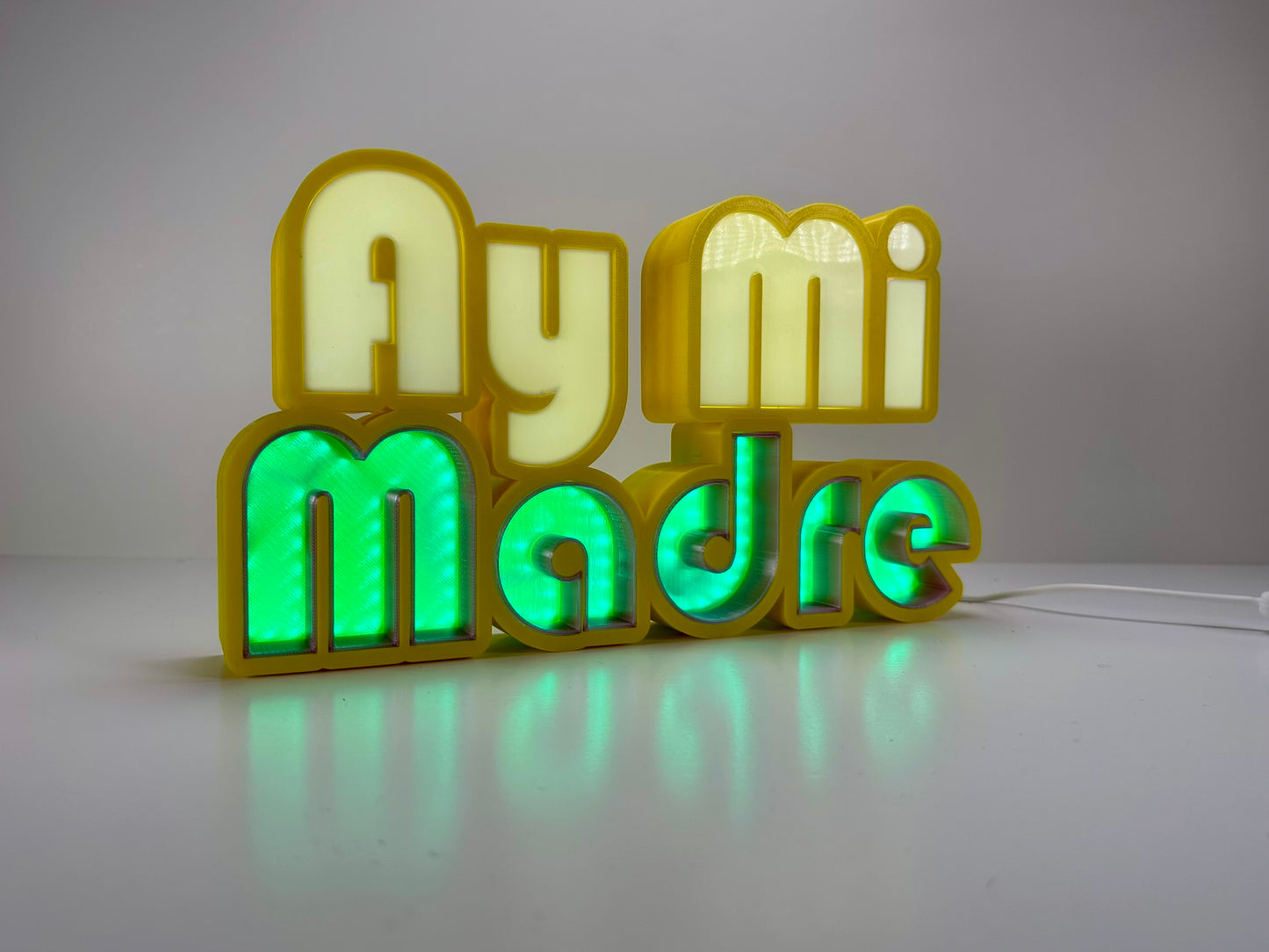 Front view of Ay Mi Madre LED Channel Letter Sign in yellow with red and white letters, showing the illuminated effect against a white background.