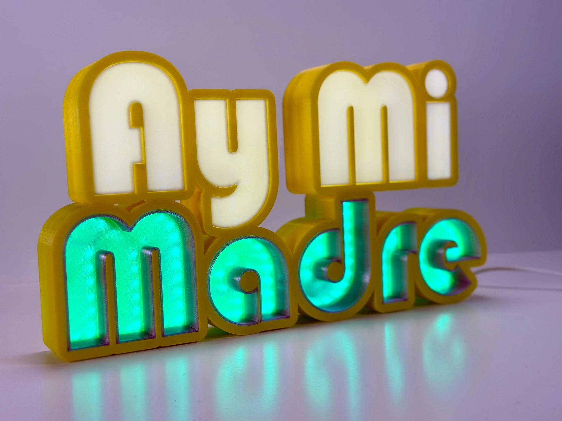 Front view of Ay Mi Madre LED Channel Letter Sign in yellow with white letters, illuminated with a green light against a white background.
