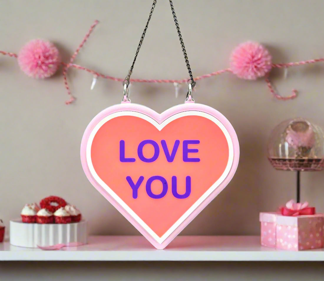 Close-up of LED heart signs: pink 'LOVE YOU' and purple 'HUG ME.' Valentine’s gift.