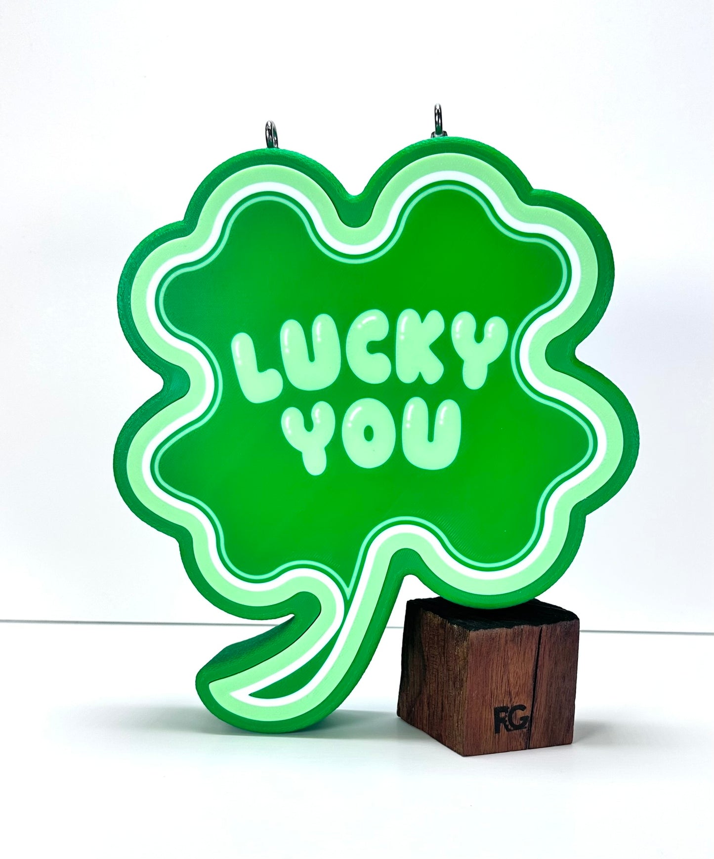Custom Shamrock LED Sign with “Lucky You” text, standing on a wooden base against a white background