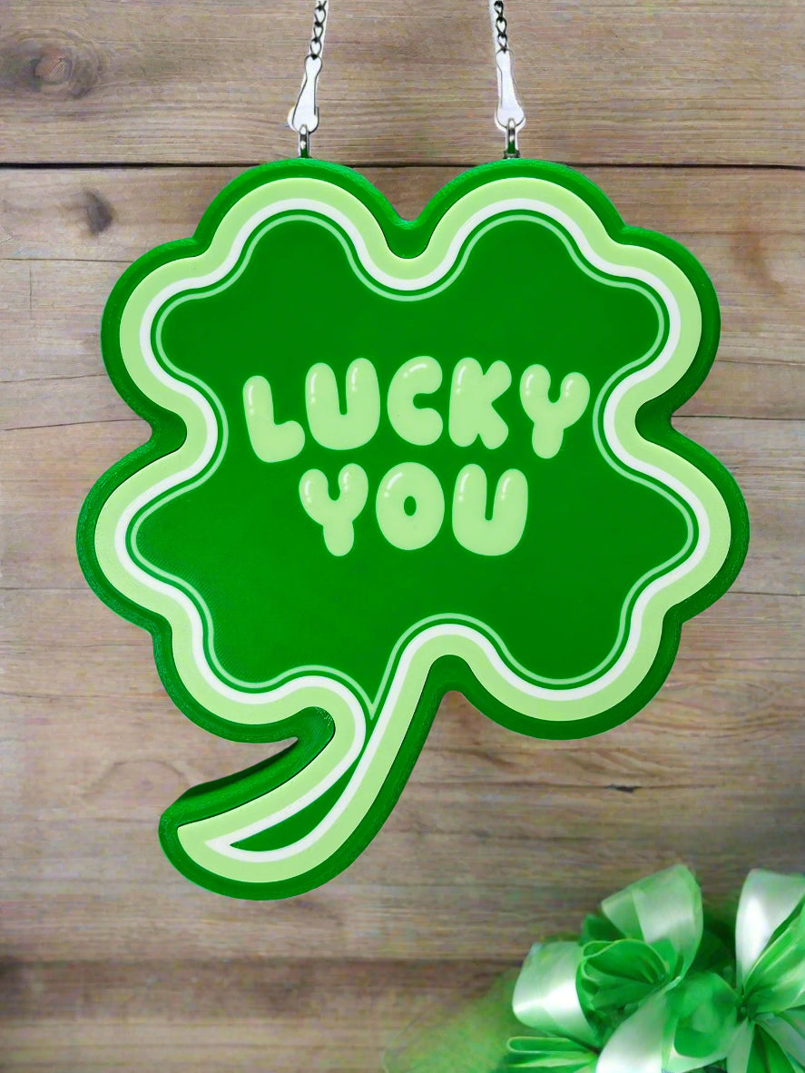 Shamrock LED sign with “Lucky You” text, glowing brightly, next to themed St. Patrick’s Day decorations