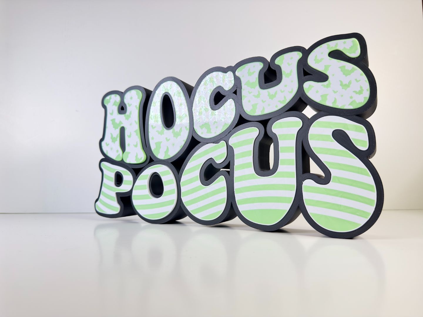 Close-up of the “Hocus Pocus” LED sign showcasing the detailed bat and stripe patterns in green with LED lighting