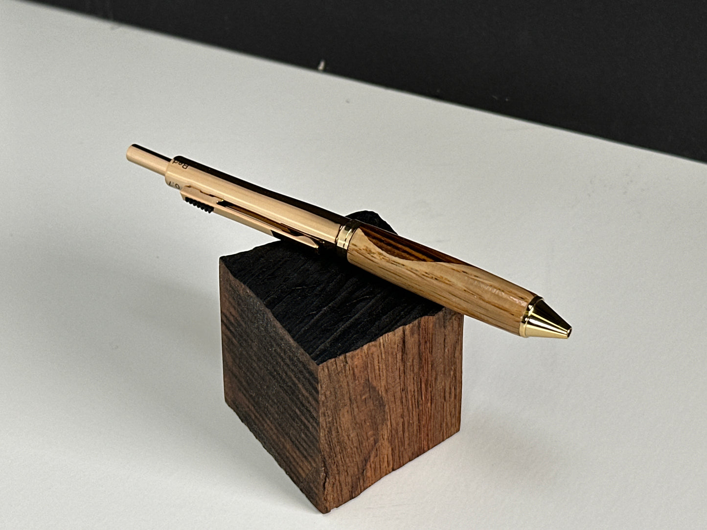 Oak and zebrawood pen on a rustic wooden stand