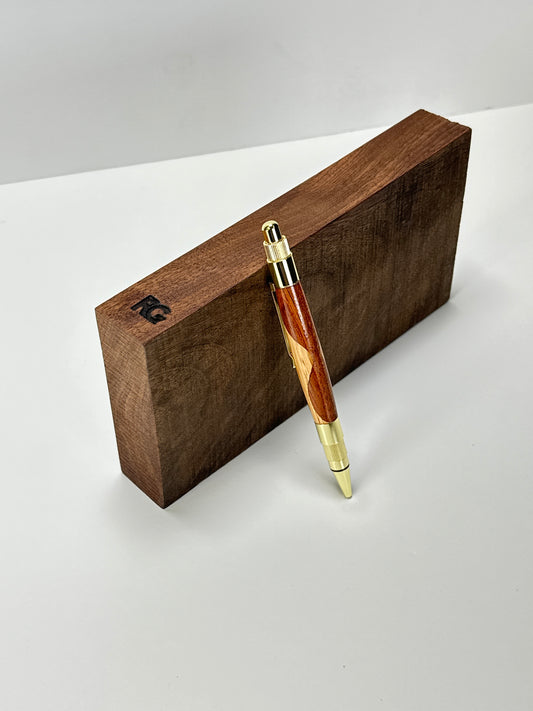 Sapele and oak pen on a wooden block.