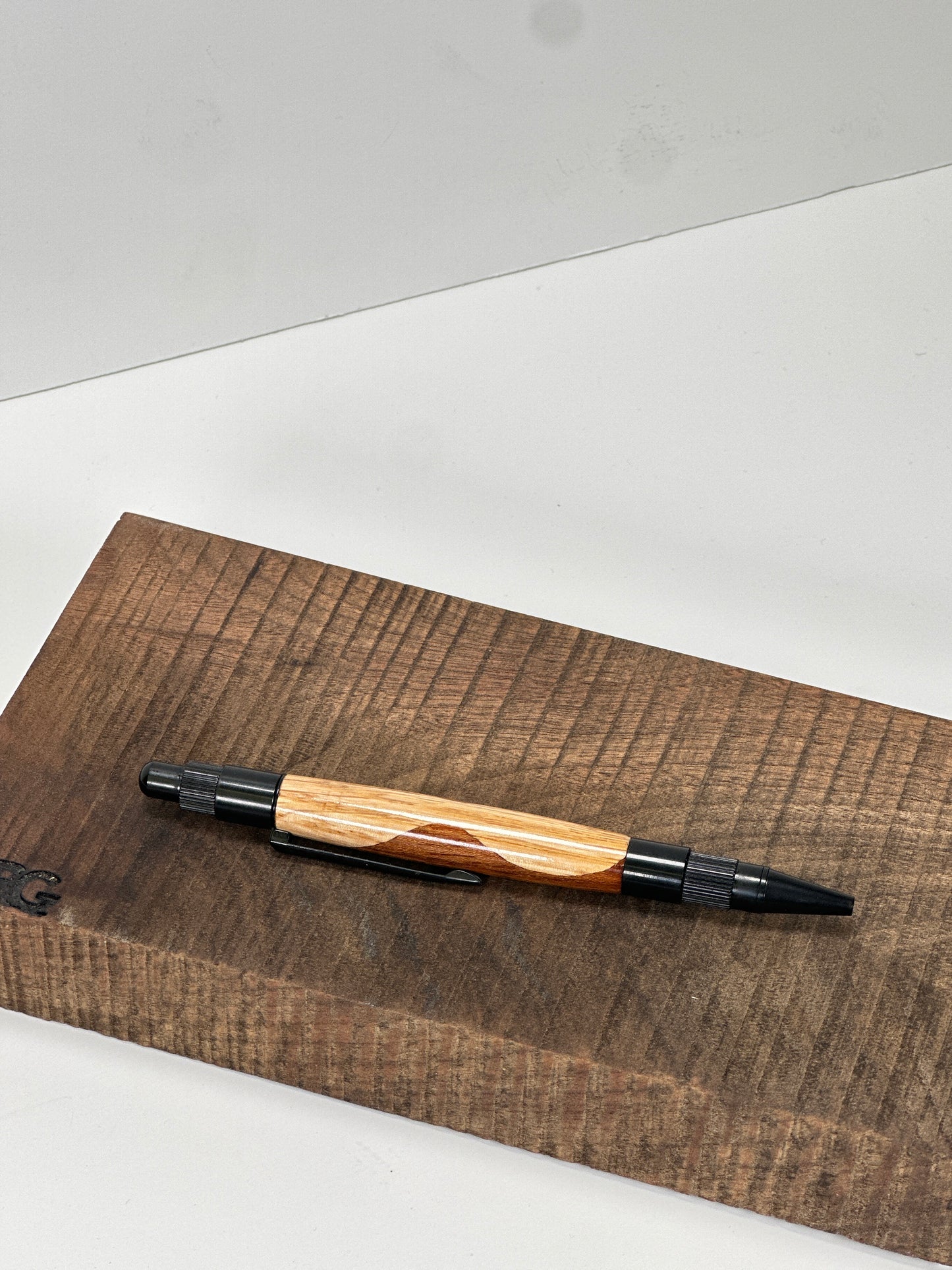 Close-up of a wooden pen with black hardware