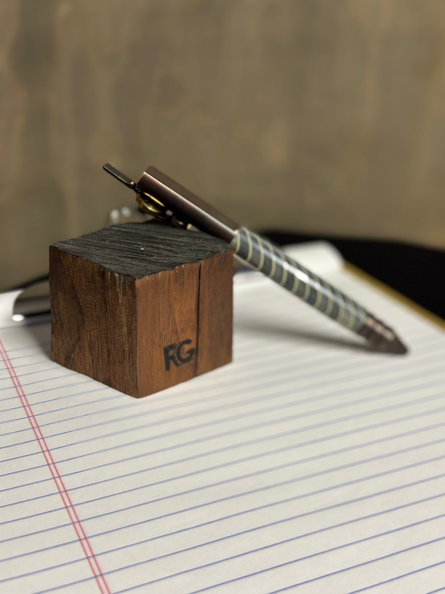Wooden block with a metal rod on lined paper