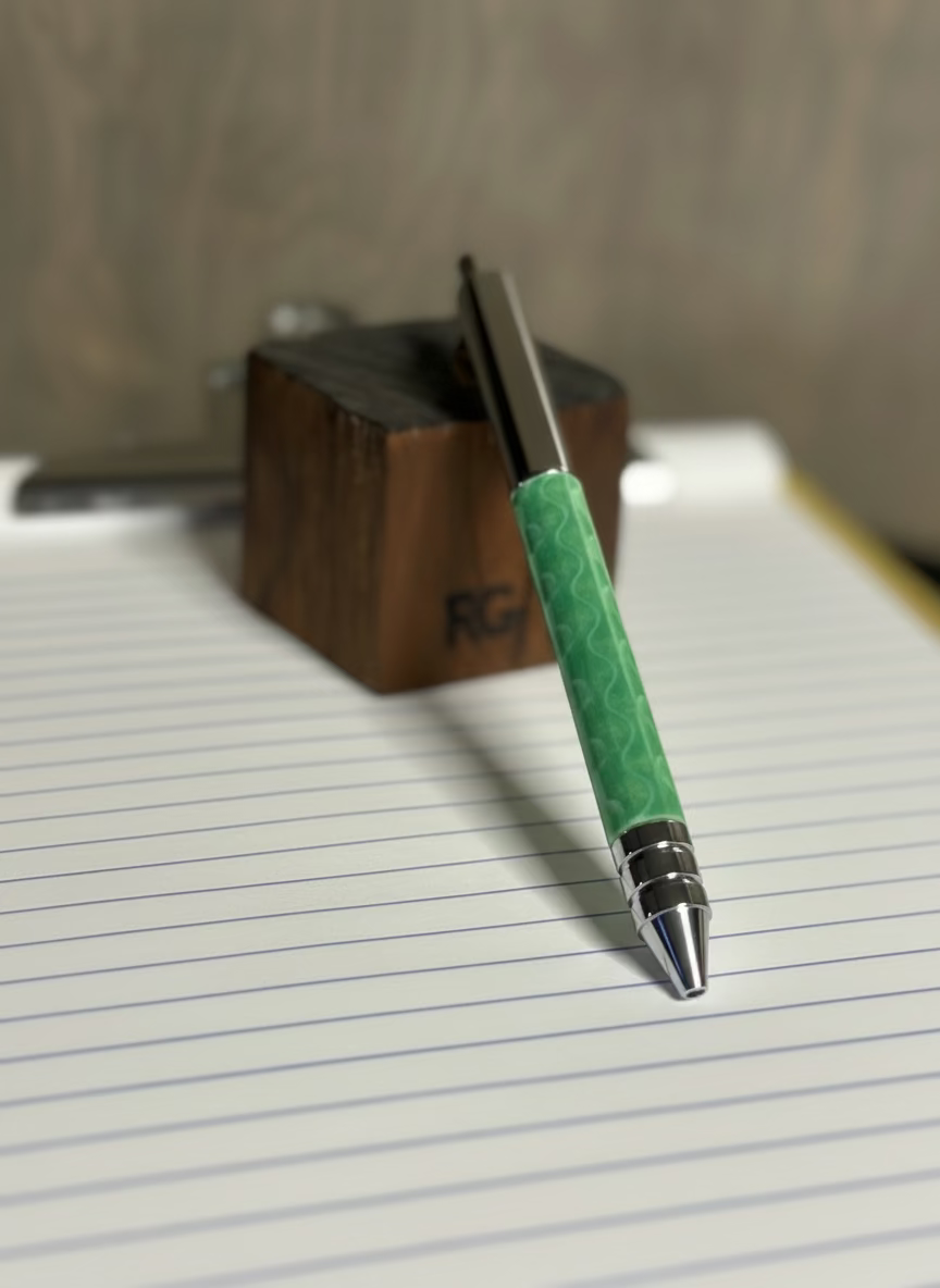 Green pen with silver cap on a sheet of lined paper