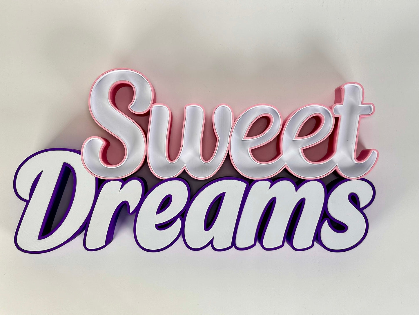 Front view of the Sweet Dreams LED Channel Sign with vibrant pink and purple colors, displayed against a white background, showcasing the elegant and modern design suitable for home decor.