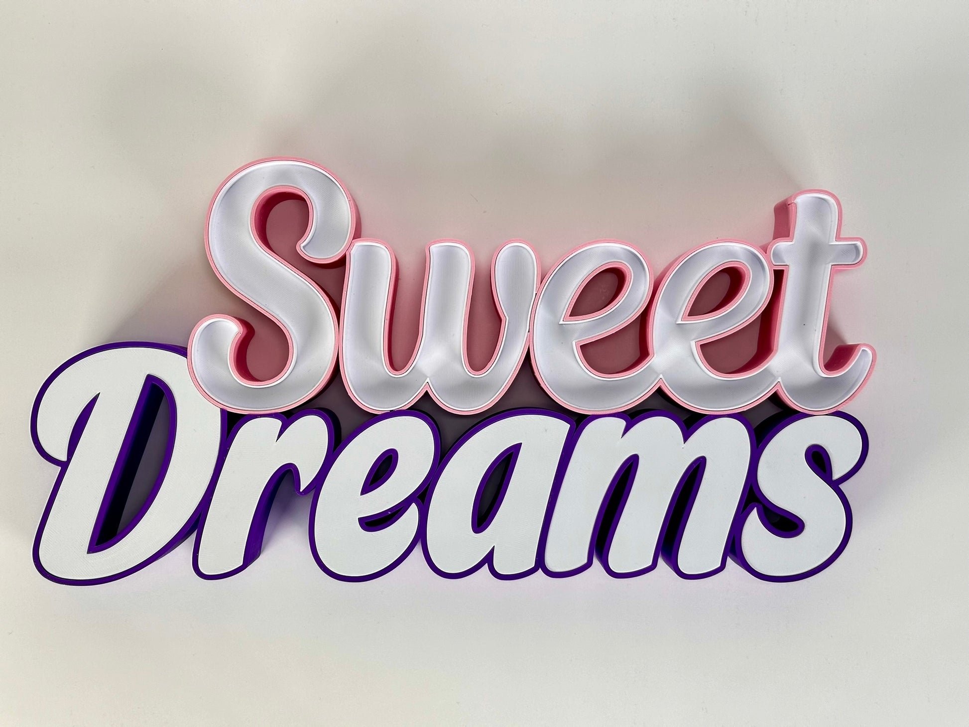 Front view of the Sweet Dreams LED Channel Sign with vibrant pink and purple colors, displayed against a white background, showcasing the elegant and modern design suitable for home decor.