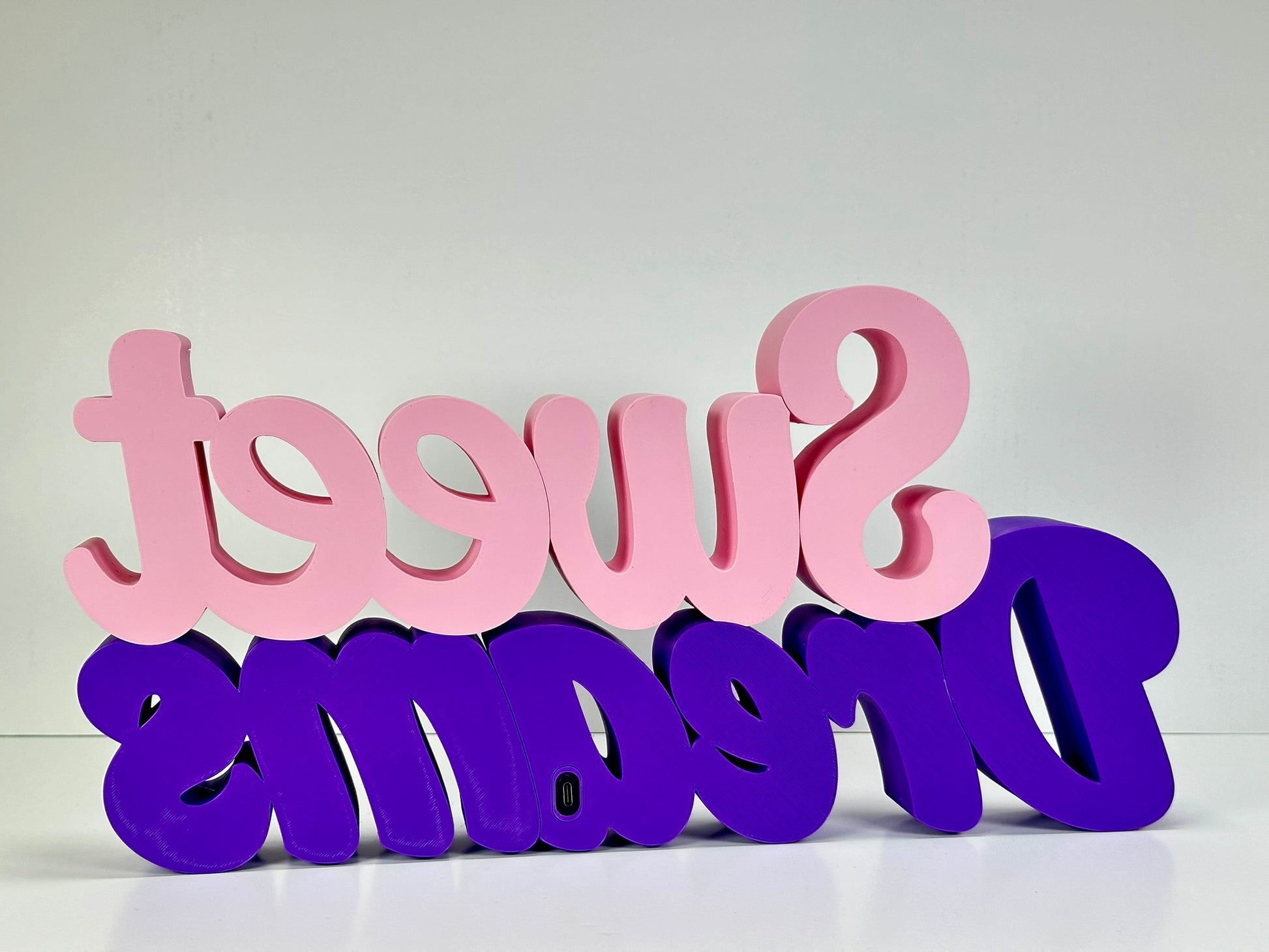 Rear view of the Sweet Dreams LED Channel Sign, showcasing the vibrant pink and purple colors and the back design details. The sign is positioned against a white background, emphasizing its construction and quality, perfect for home decor.