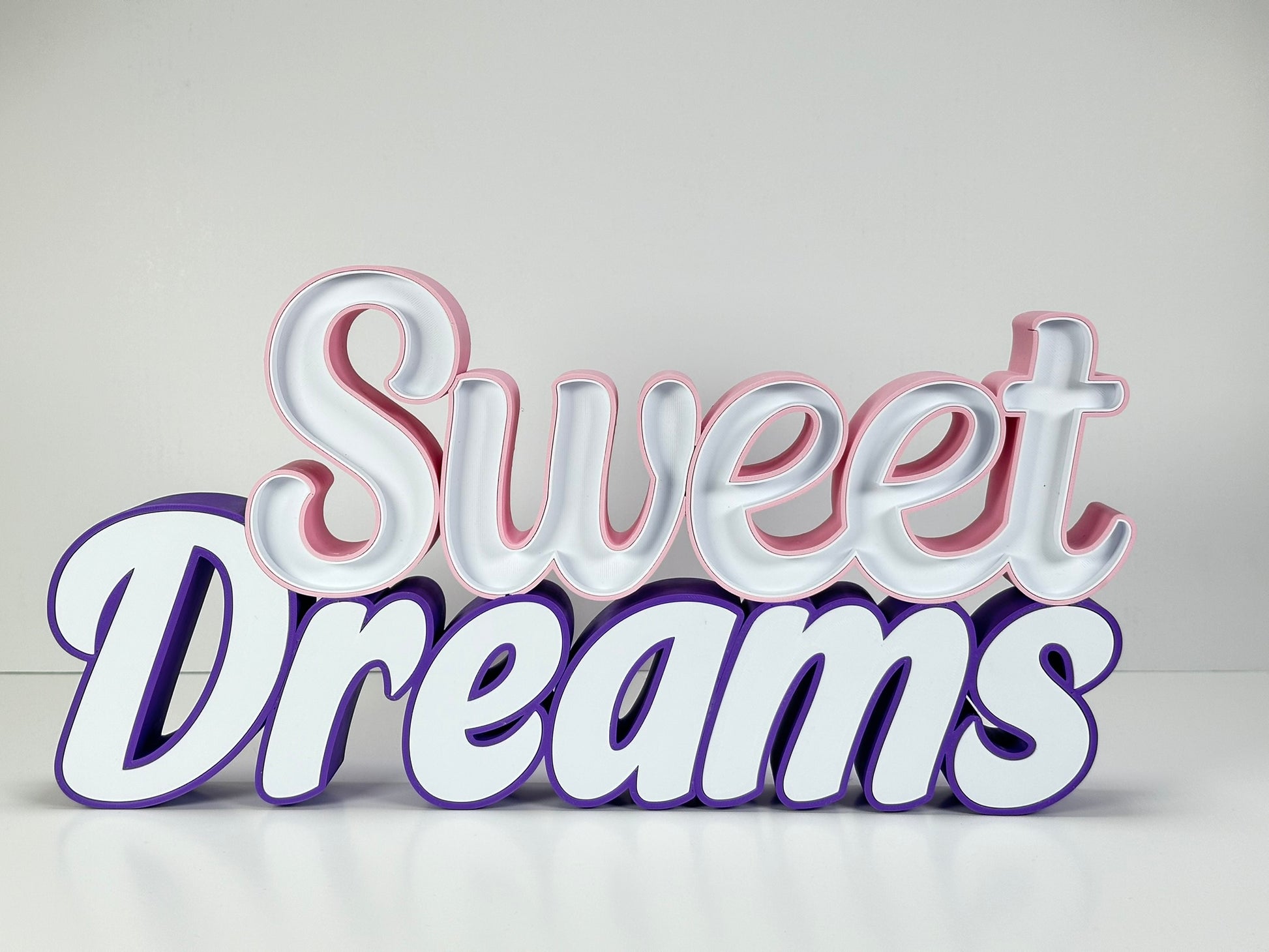 Front view of the Sweet Dreams LED Channel Sign with vibrant pink and purple colors, displayed against a white background, showcasing the elegant and modern design suitable for home decor.