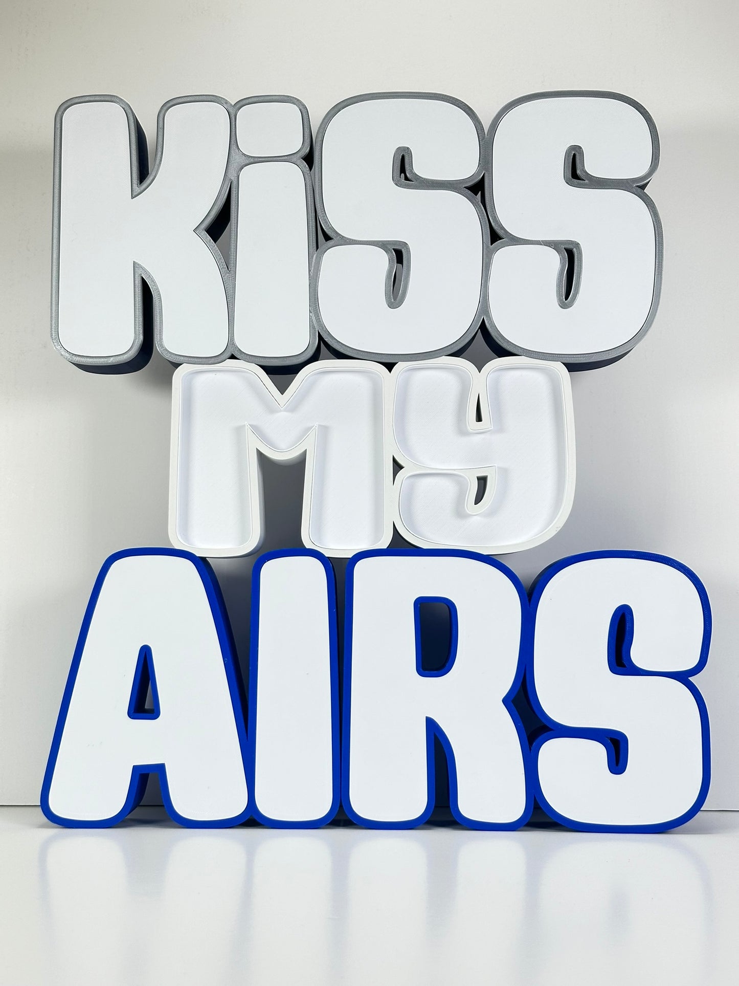 Front view of the Kiss My Airs LED Channel Letter Sign with bold white letters and black outlines, displayed against a white background