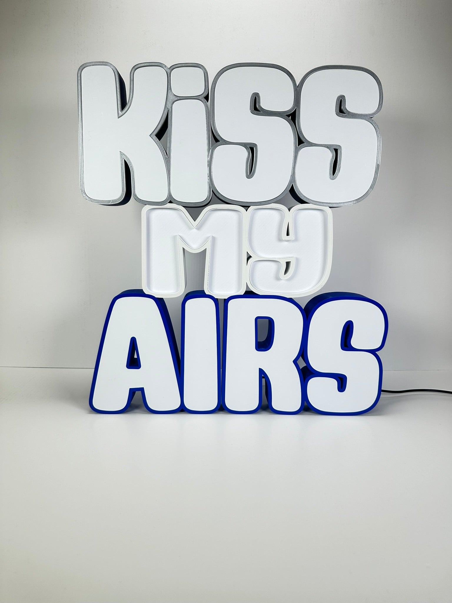 Front view of the Kiss My Airs LED Channel Letter Sign with bold white letters and blue outlines, displayed against a white background.