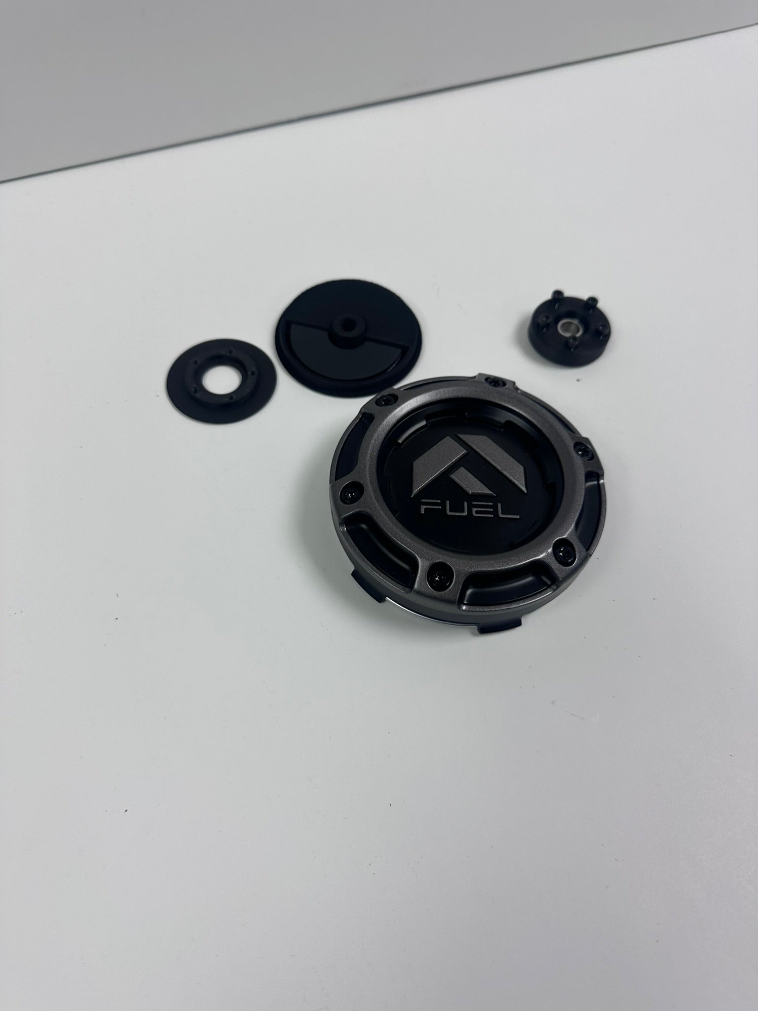 Fuel Wheel Floating Center Cap components, including the main cap with a Fuel logo, bearing, and weight, arranged on a white surface.