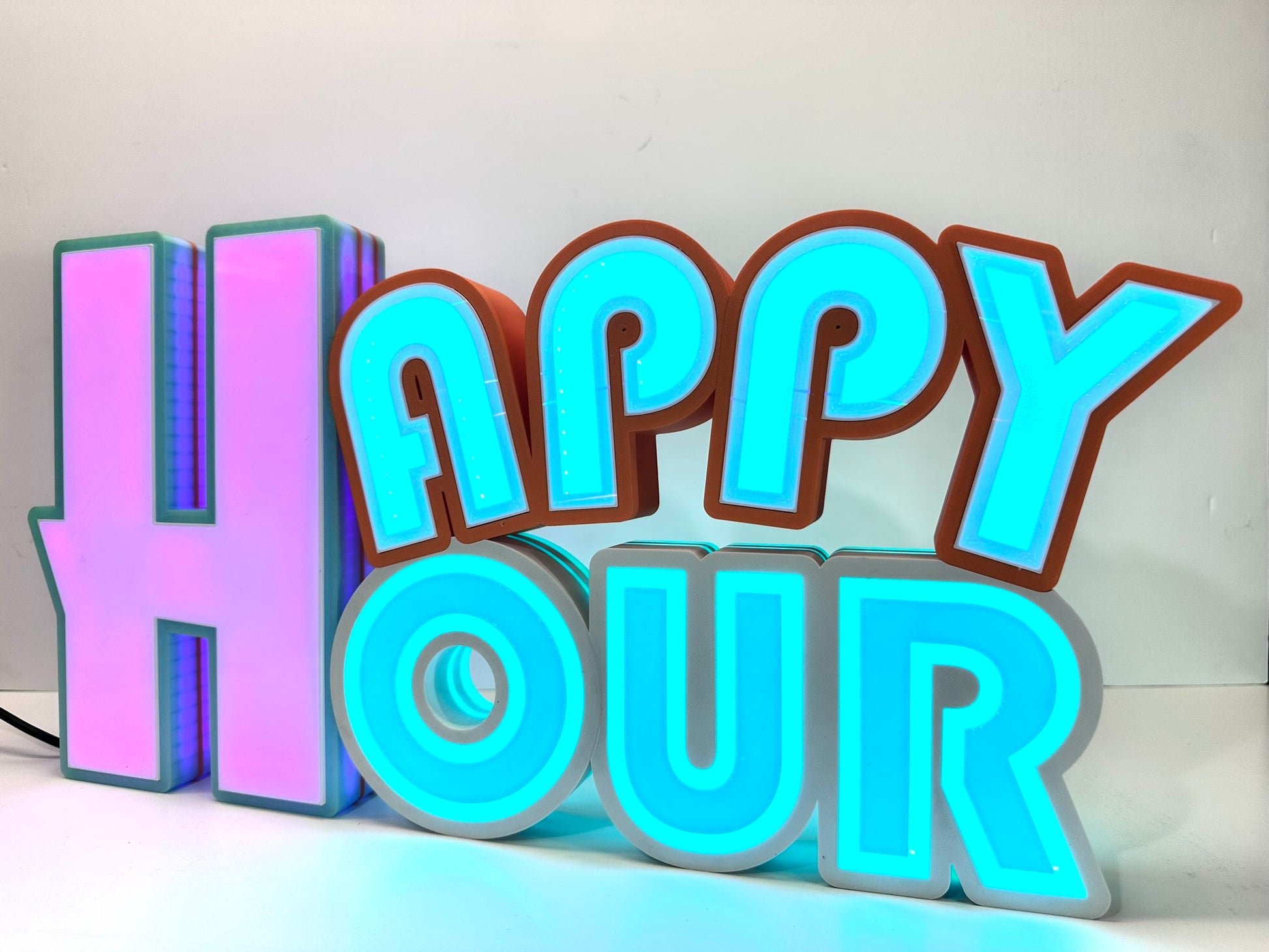 Illuminated 'Happy Hour' sign with purple and blue LED lights glowing, creating a vibrant party atmosphere.