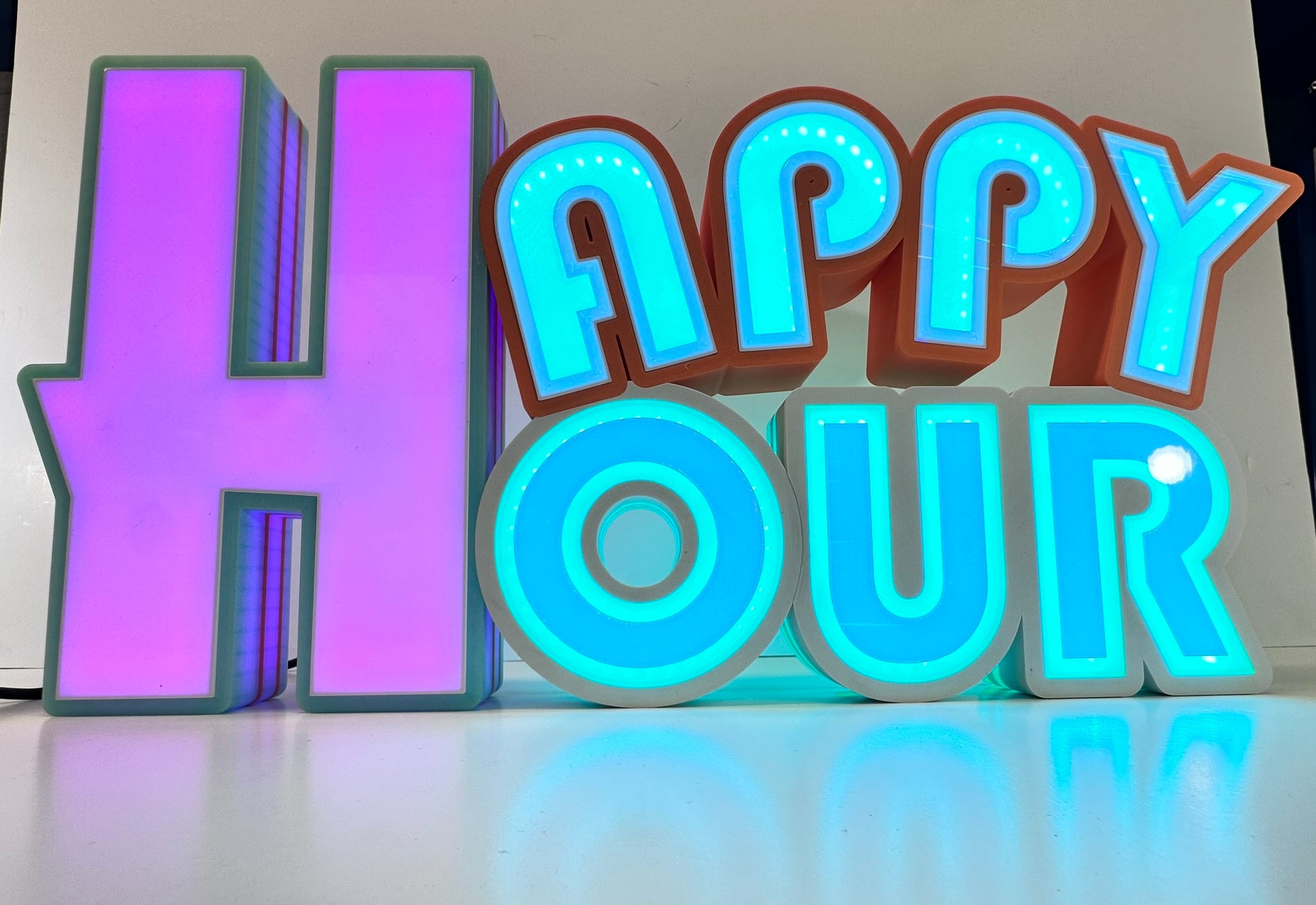 Brightly illuminated 'Happy Hour' sign with glowing purple and blue lights, enhancing the vibrant, playful atmosphere