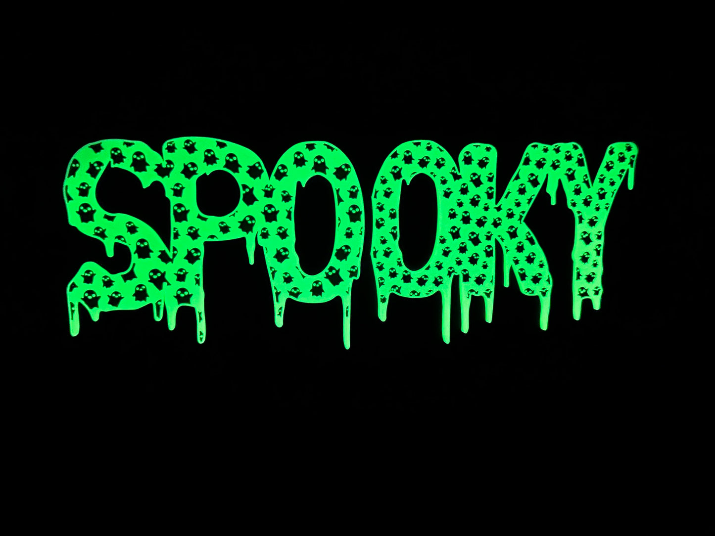 The “Spooky” LED sign glowing in the dark, with bright green lighting highlighting the mini ghost pattern inside the letters, perfect for Halloween decor.