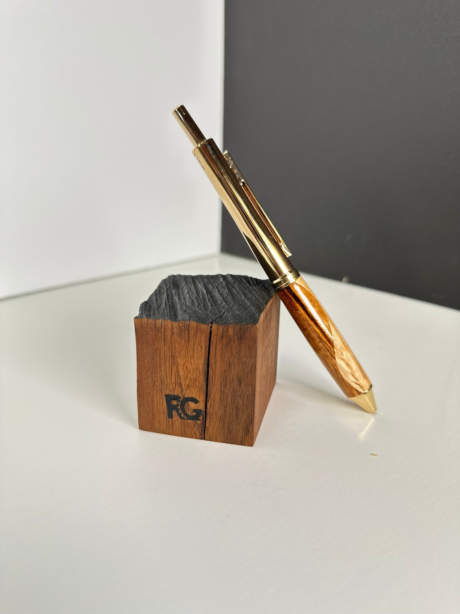 Oak and zebrawood pen displayed on a wooden block