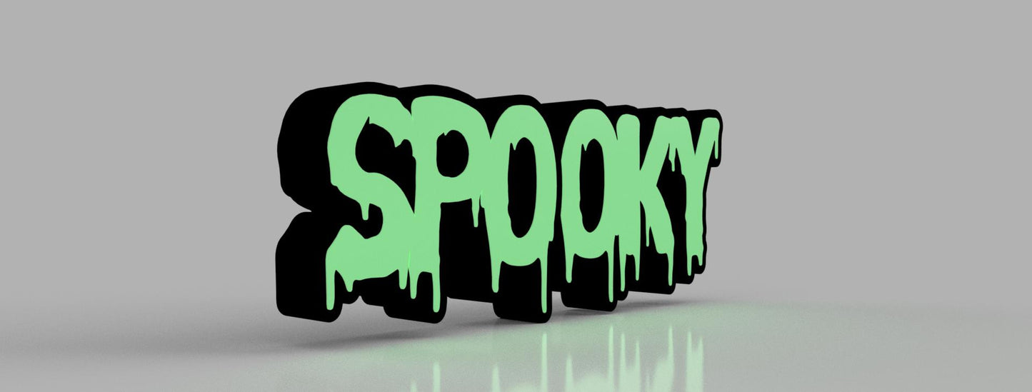 A reverse side view of the “Spooky” sign with dripping text design, showcasing the green and black contrast, displayed on a reflective surface with a neutral background.